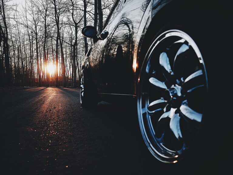Roda cromada de um carro preto ao pôr do sol